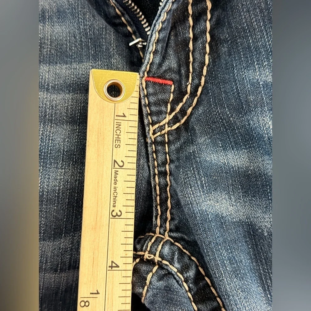 True Religion jeans feature a dark wash and bold signature stitching. Skinny